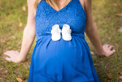 maternity photos with blue dress and white baby shoes