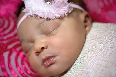 newborn girl with pink headset and pink blanket jacksonville