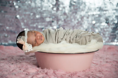 newborn girl in pink basket for photos jacksonville