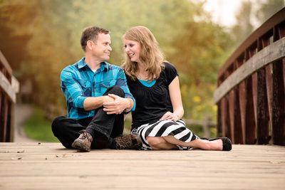 Engagement Photos of a Couple Sitting on a Bridge