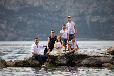 Family sitting on the rocks, trash the dress Lake Garda