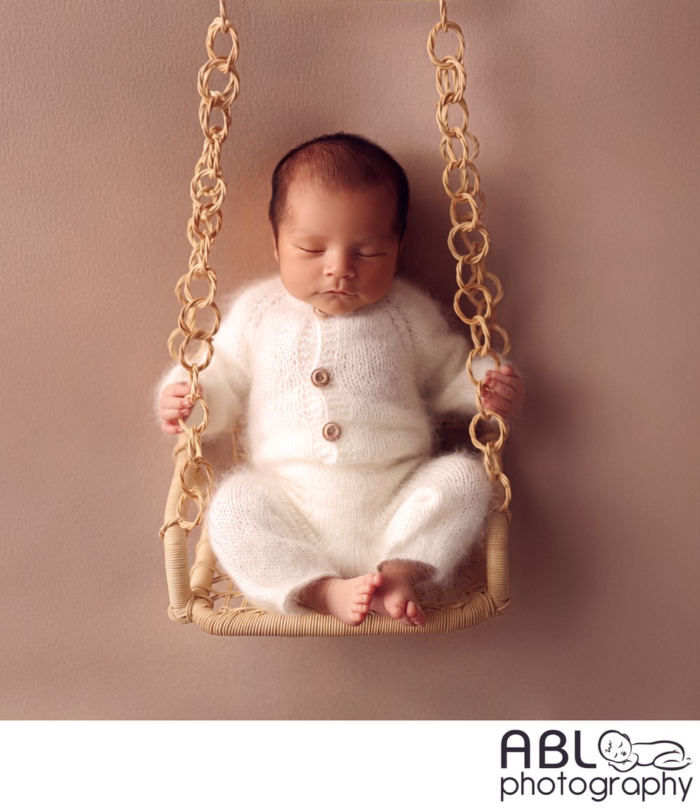 baby on swing in newborn photo studio Poway, CA