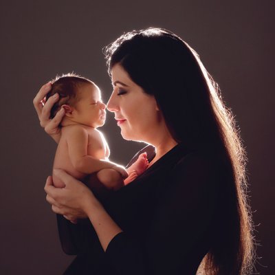 San Diego family photographer with mom kissing newborn