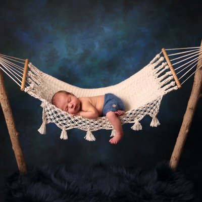 newborn baby in blue hammock