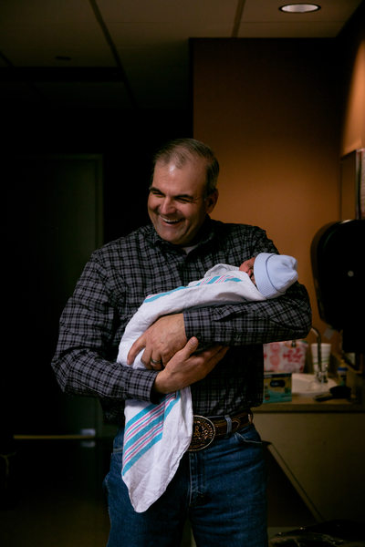 Father Holds Newborn at Home 