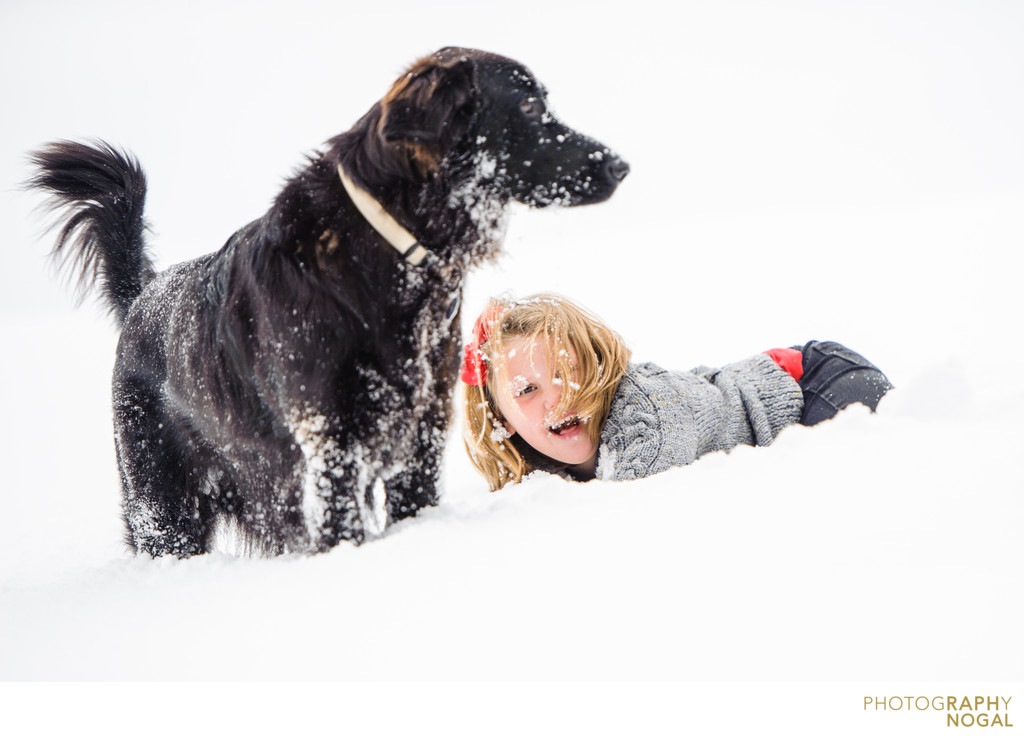 girl playing with dog in the snow