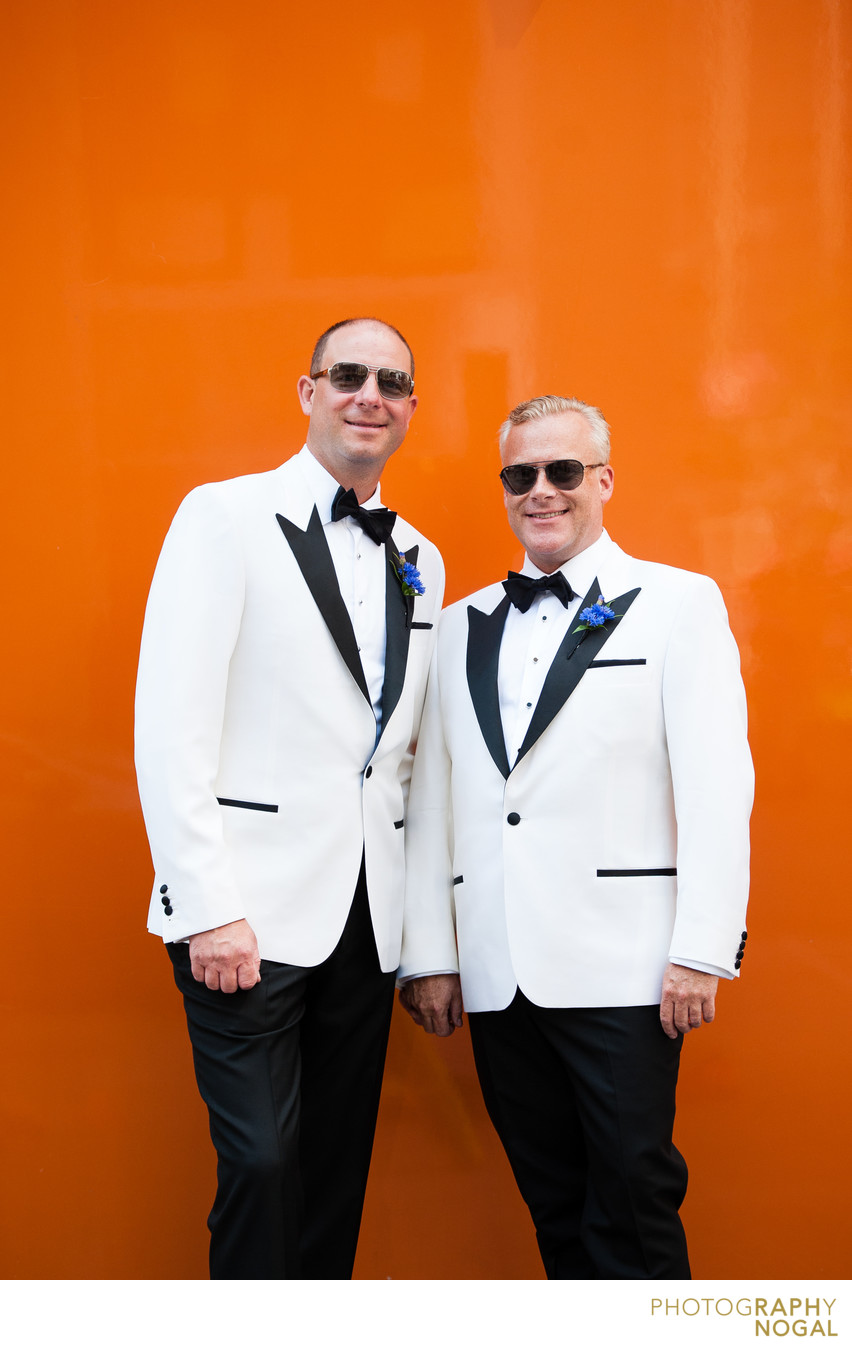 Same Sex Couple Looking Sharp by an Orange Wall