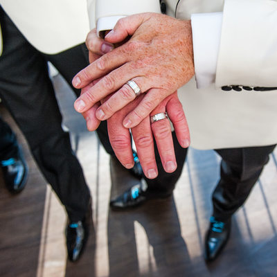 Gay Couple Showing Wedding Rings To Camera