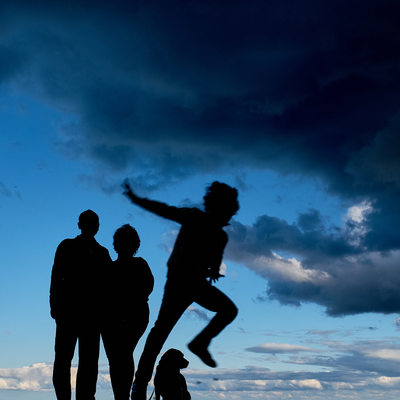 Silhouette of a family and kid jumping