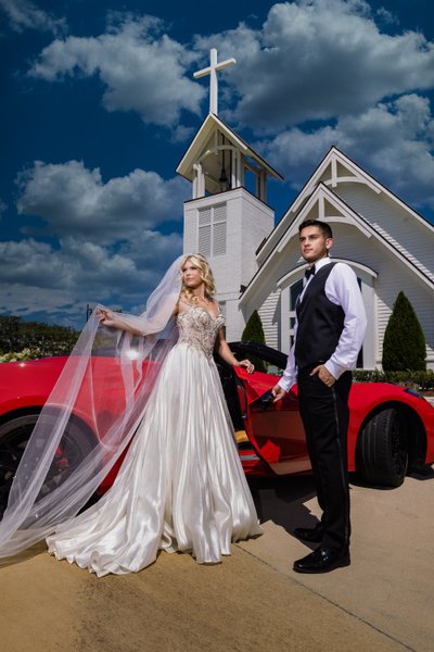 Dramatic wedding couple with red corvette