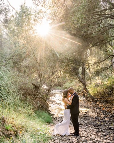 Bride and Groom by a stream at sunset