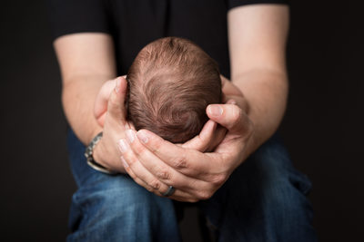 Newborn Photo of Baby in Dad's Hands - Baby Hair