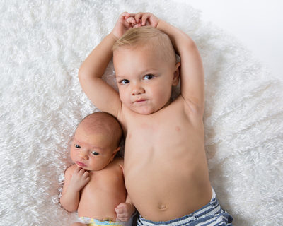 Two Year Old Boy Poses with Newborn Baby Brother