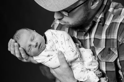 Dad Holds Son in Hands- Newborn Photographer in Malvern