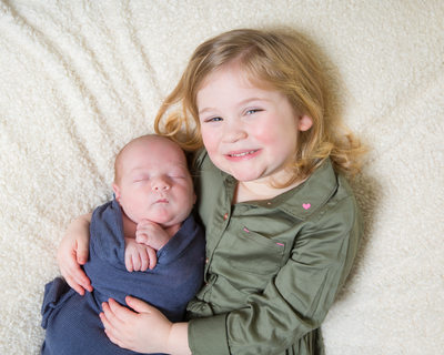 Proud Big Sister Holds Newborn Baby Brother