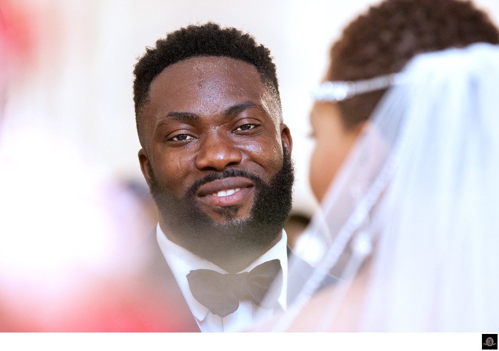 Perspiring groom smiles during the wedding ceremony