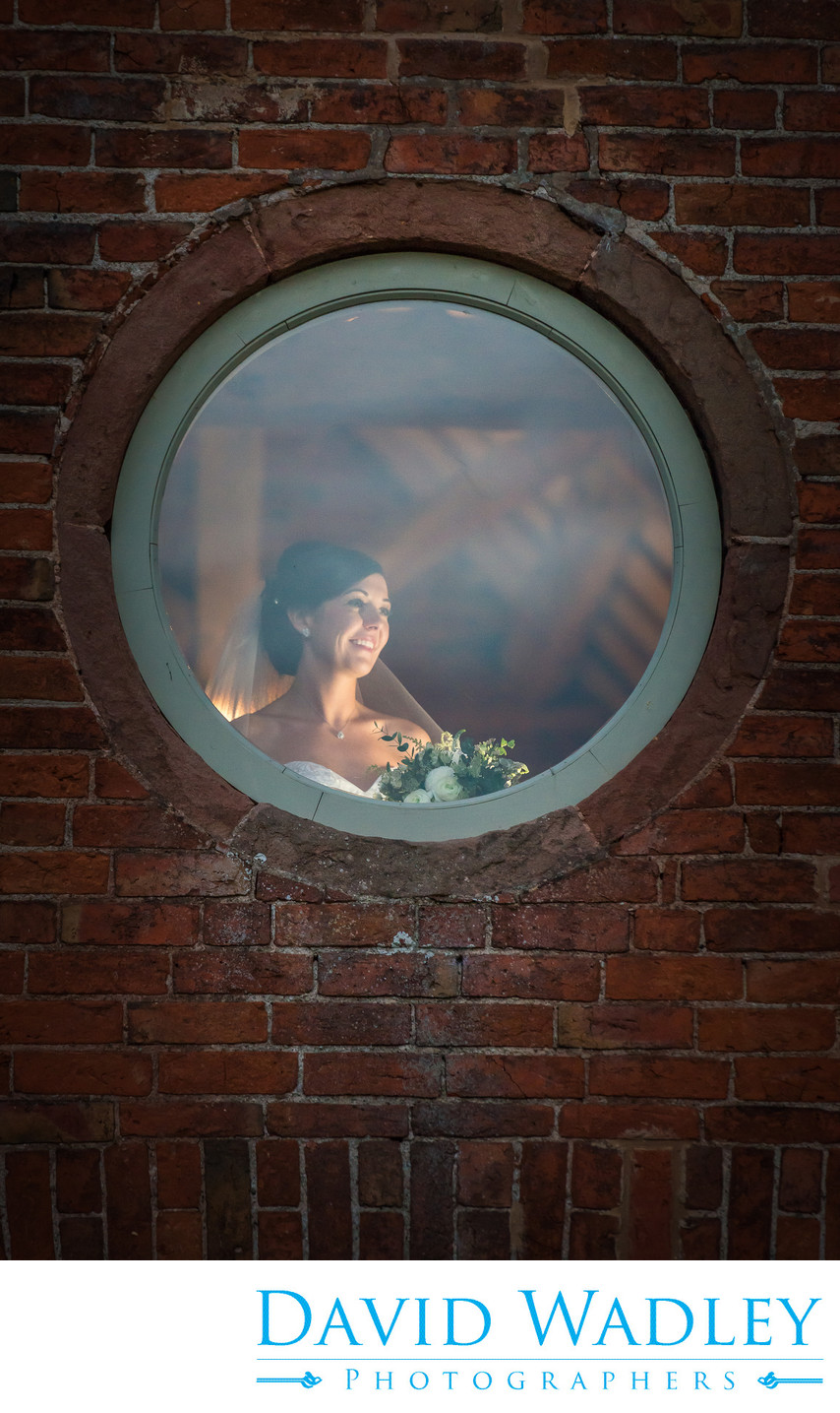 Bride photographed in window at Shustoke Barn.