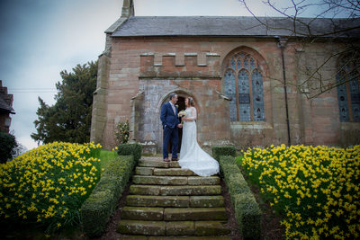 The bride & groom outside the John Morris Hall on their wedding day at Grafton Manor