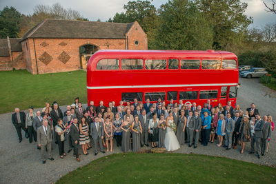 Bride & Groom with all their wedding guests photographed outside stunning Shustoke Barns.