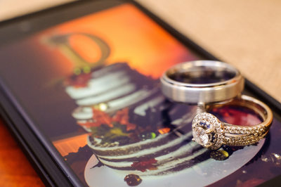 Unique shot featuring wedding rings placed on an iphone