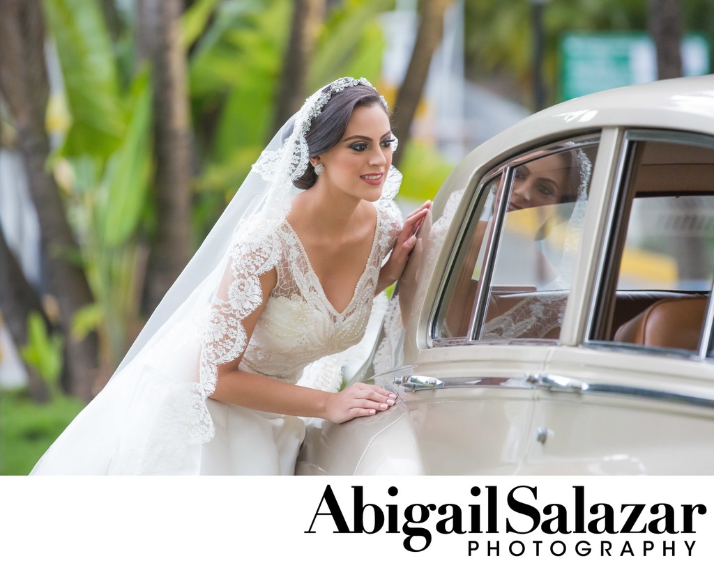Gorgeous & elegant bride poses by wedding car