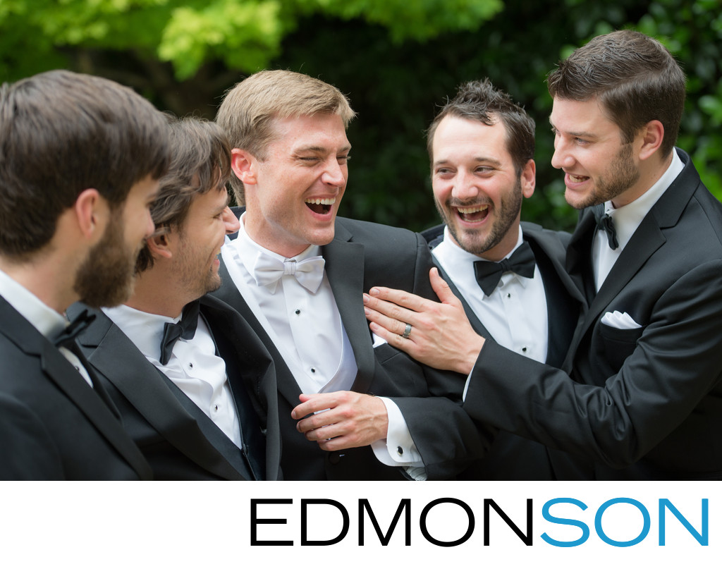 Groomsmen Laughing With Groom On Wedding Day Outdoors
