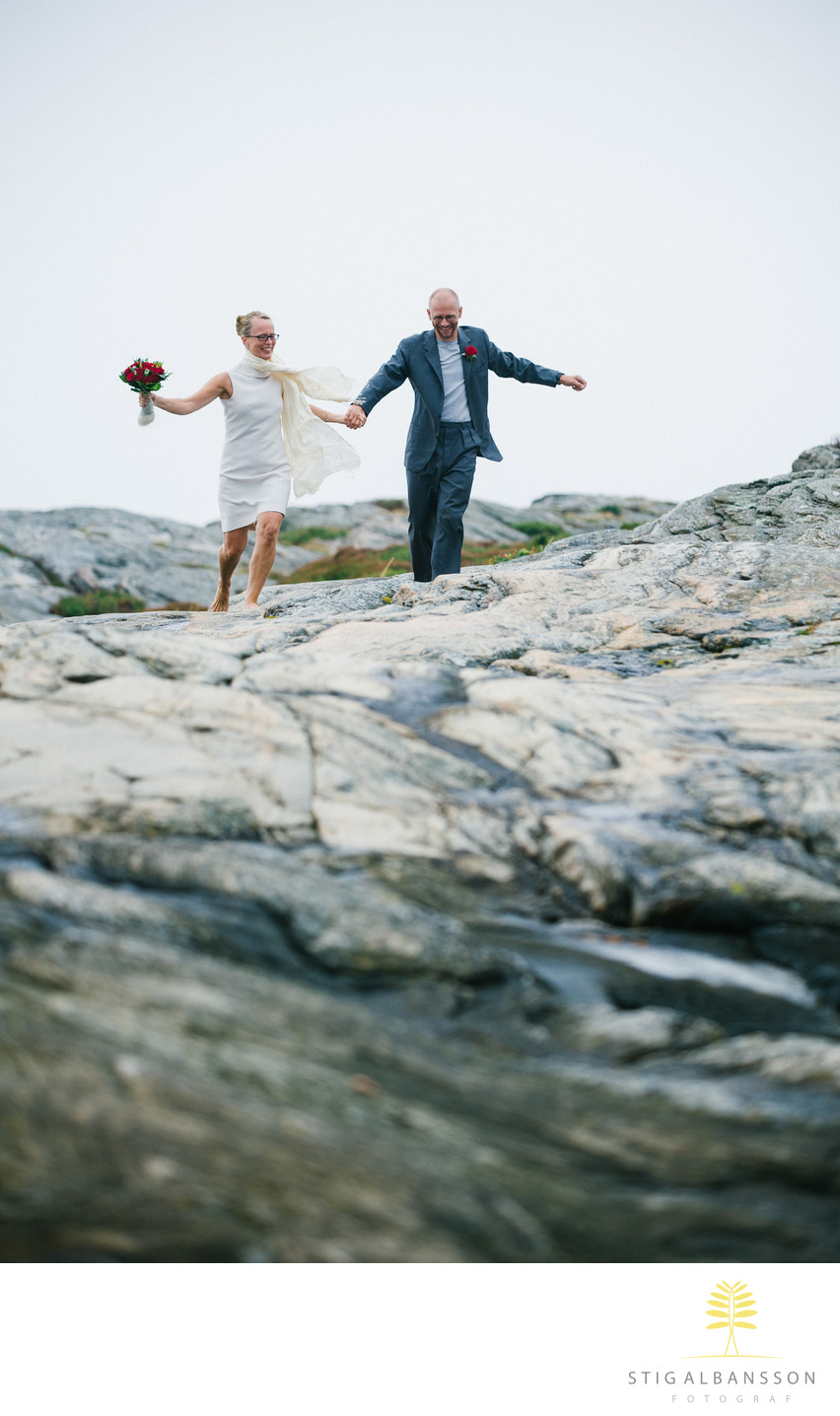 Fotografering av brudpar springer på klippor Västkusten