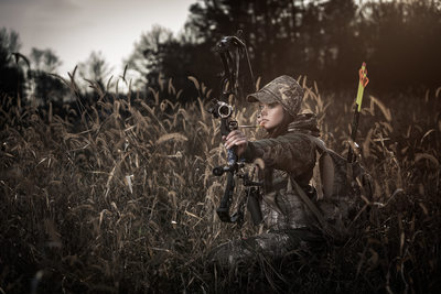 Female bow hunter in field
