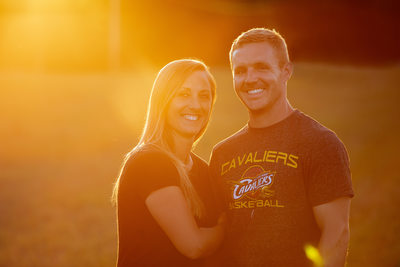 Engaged couple posing and smiling at sunset