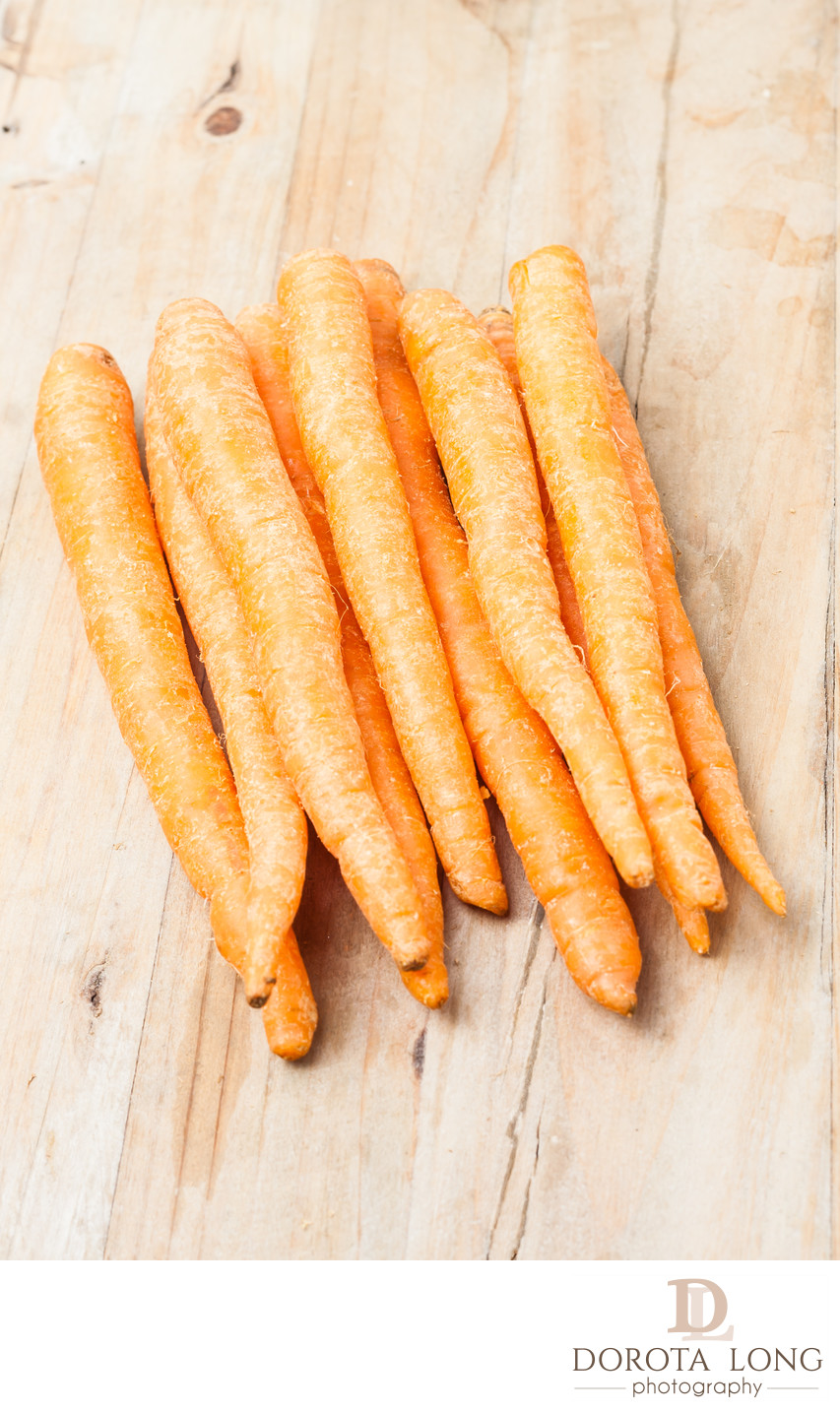 a bunch of fresh picked carrots on wooden background