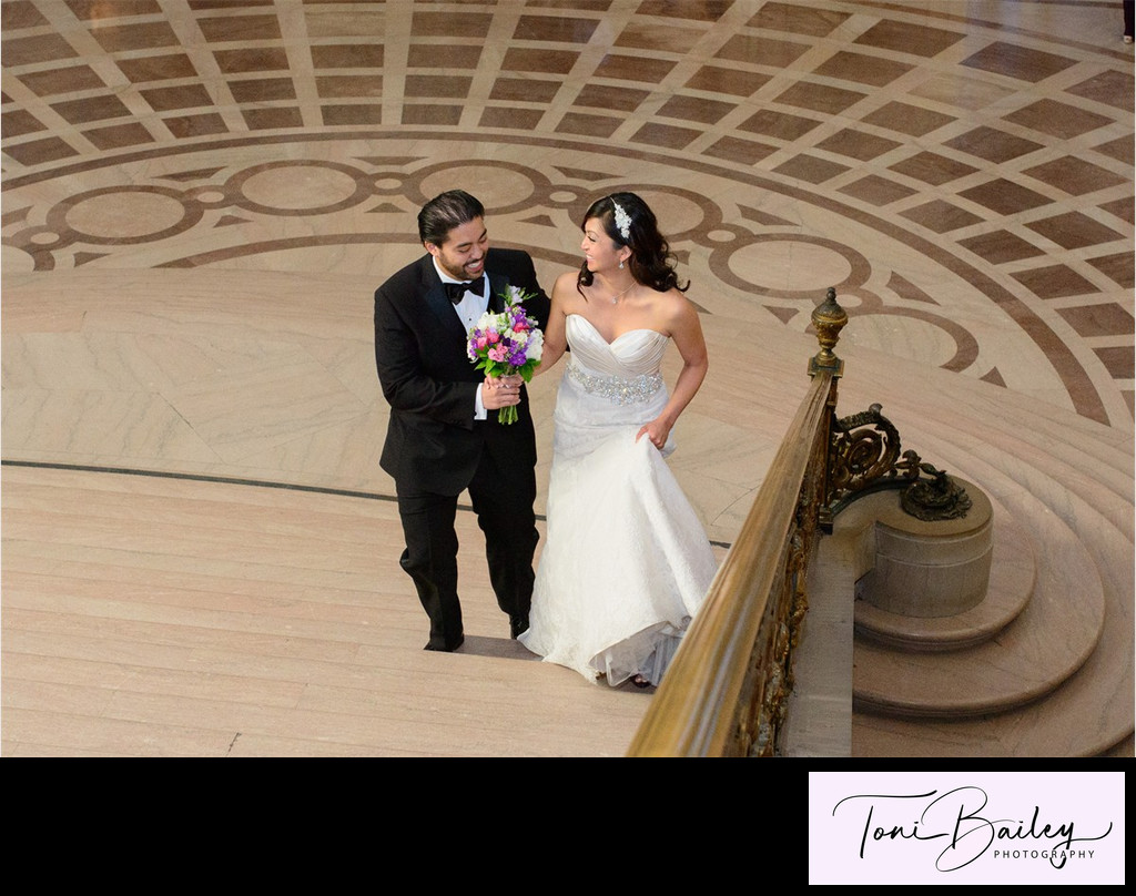 beautiful couple walking up the grand staircase