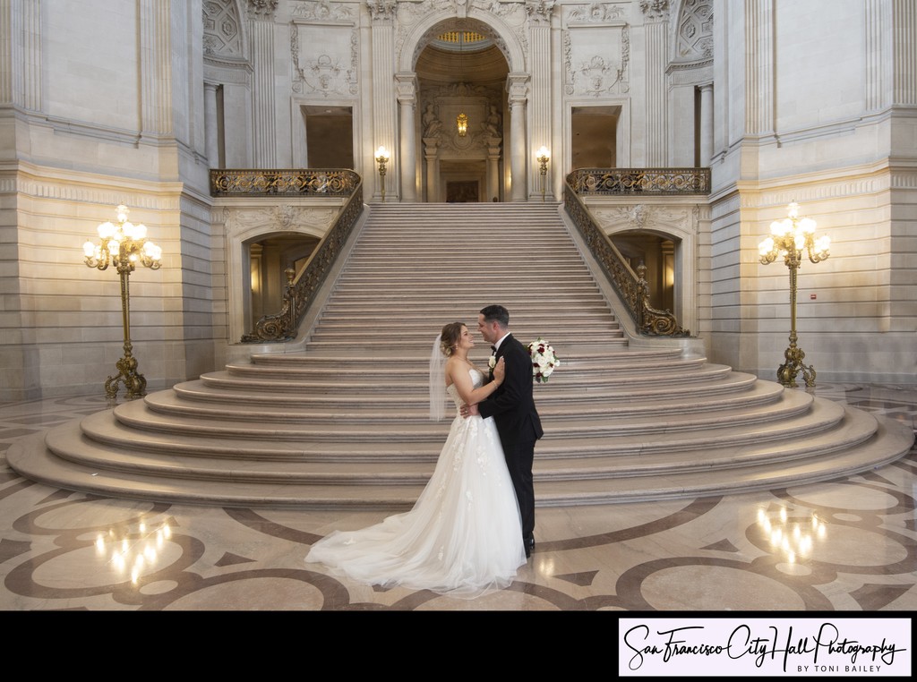SF City Hall bride and groom showing love at the Grand Staircase