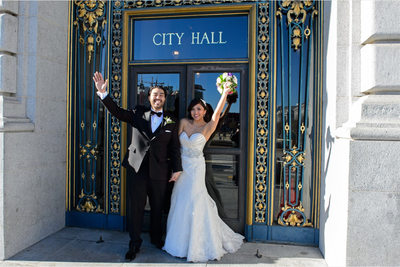 newlyweds at city hall door sign