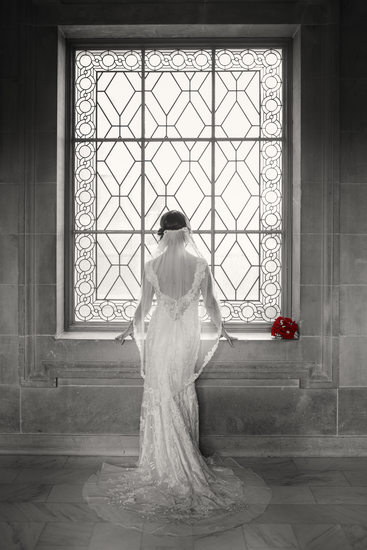 Bride with red roses in window