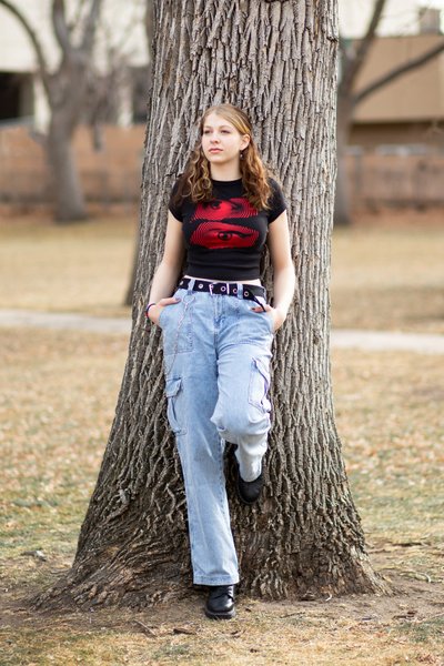 Senior Girl Standing Against Large Tree