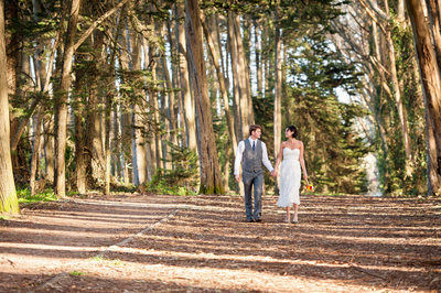 A couple hand in hand in the Presidio after Elopement CIty Hall