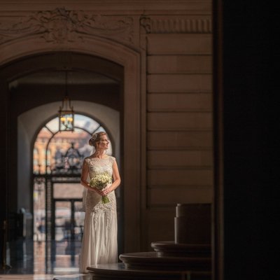Bridal Elegance: Soft-Lit Doorway Moment with Bouquet