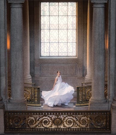 bride shows off dress  in rembrandt lighting 