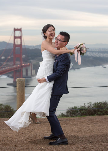 Couple Playfully lifting each other  with the  GG Bridge backfrio