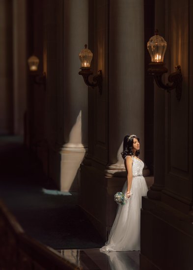 Bride in Sunlit Dress on 2nd Floor with Subdued Lamp Light