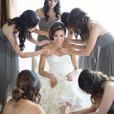 Vancouver bridesmaids in gowns help bride in Vera Wang