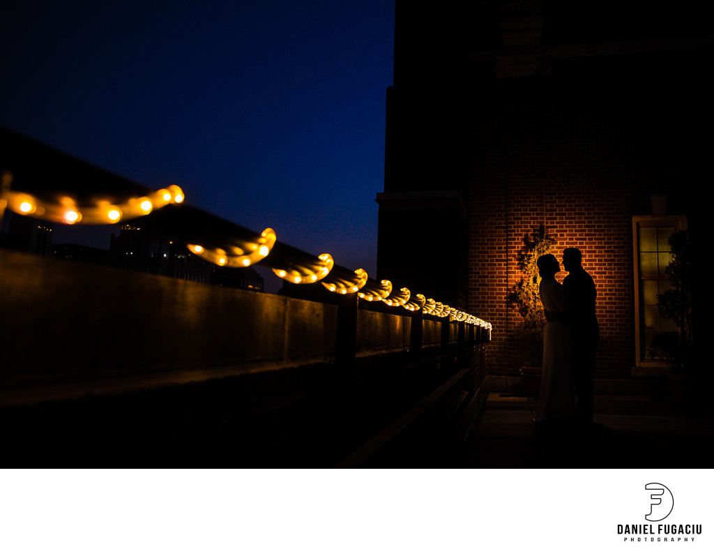 Silhouette of bride and groom at night on the rooftop
