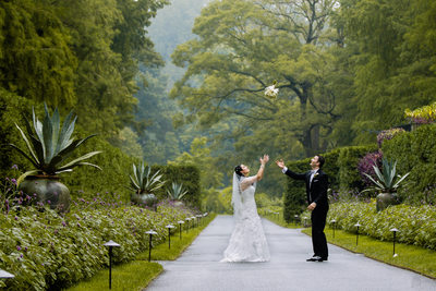 Bridal bouquet toss in the air | bride and groom