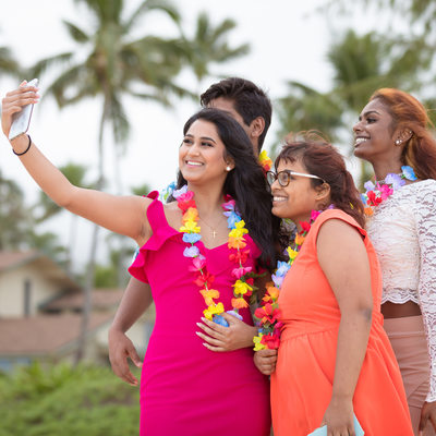 Wedding guests taking selfies on the beach