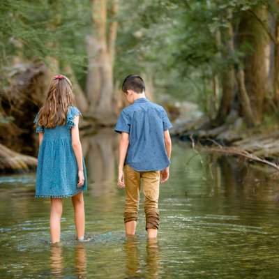 Children exploring the crystal clear water of the creek