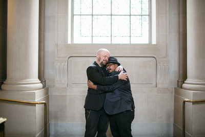 Grooms embrace after their San Francisco City Hall wedding