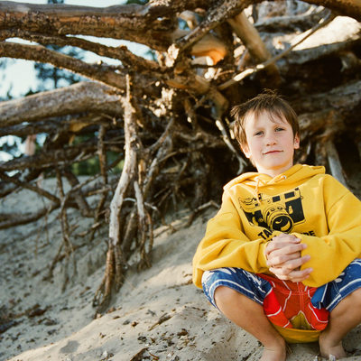 Boy in front of tree at lake Tahoe beach