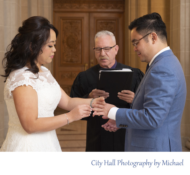 Bride placing ring on Groom during city hall marriage ceremony