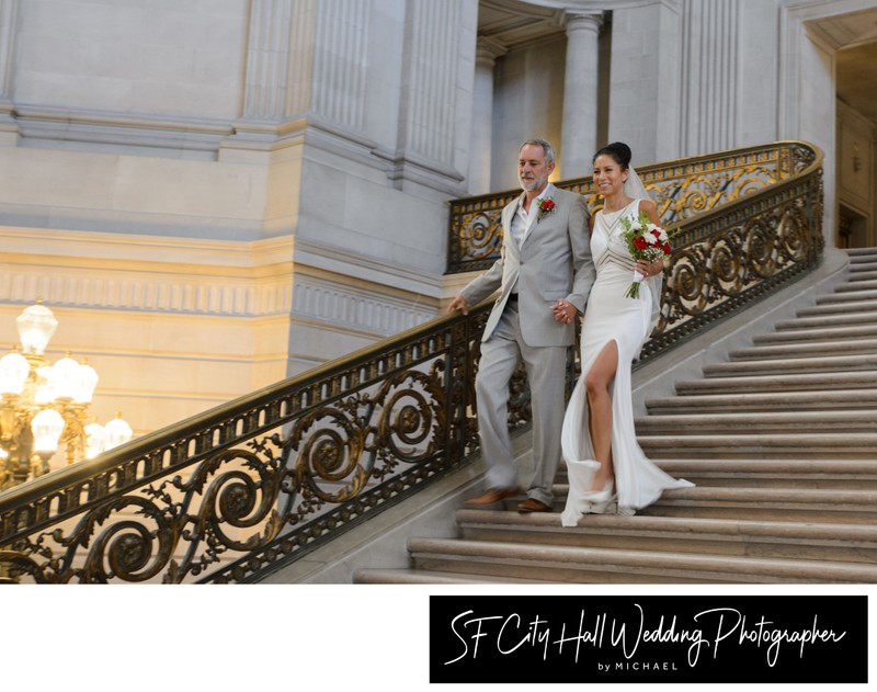Action photo of bride and groom descending the stairs after their wedding