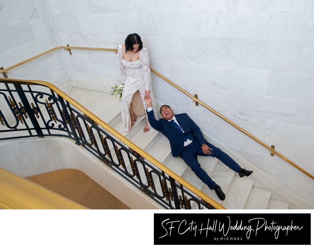 Bride dragging groom up stairs at city hall